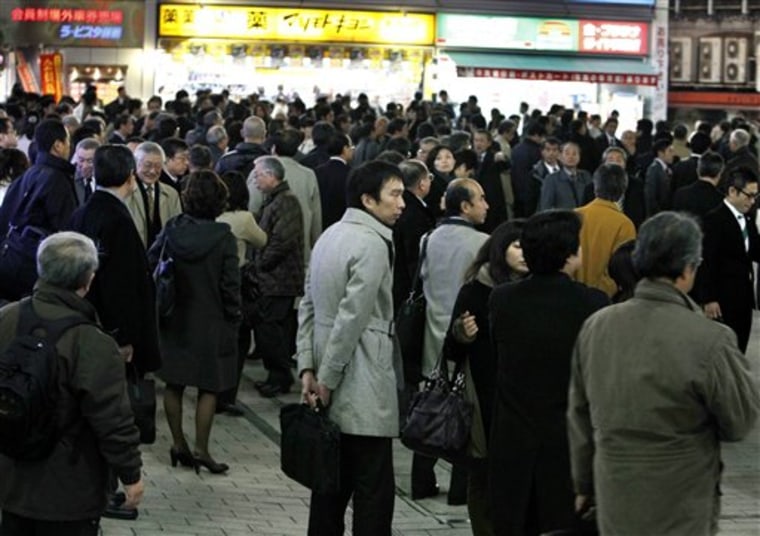 In this photo taken on Dec. 22, 2010, groups of Japanese office workers crowd in a square near a train station in Tokyo Wednesday, Dec. 22, 2010. For once-confident Japan, 2010 may well mark a symbolic milestone in its slide from economic giant to what experts see as its likely destiny: a second-tier power with some standout companies but limited global influence. As Japanese drink up at year-end parties known as \"bonen-kai,\" or \"forget-the-year gatherings,\" this is one many will be happy to forget. (AP Photo/Shizuo Kambayashi)